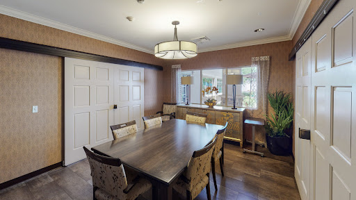 A stylish and cozy dining room featuring a wooden table, elegant chairs, and natural light.