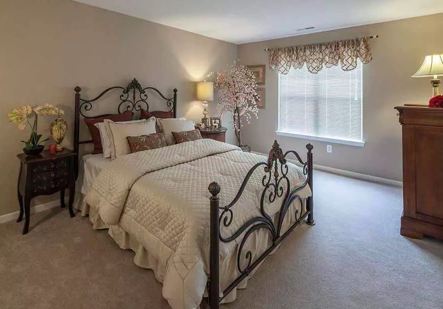 A cozy bedroom with an elegant wrought iron bed frame, soft bedding, and warm lighting.