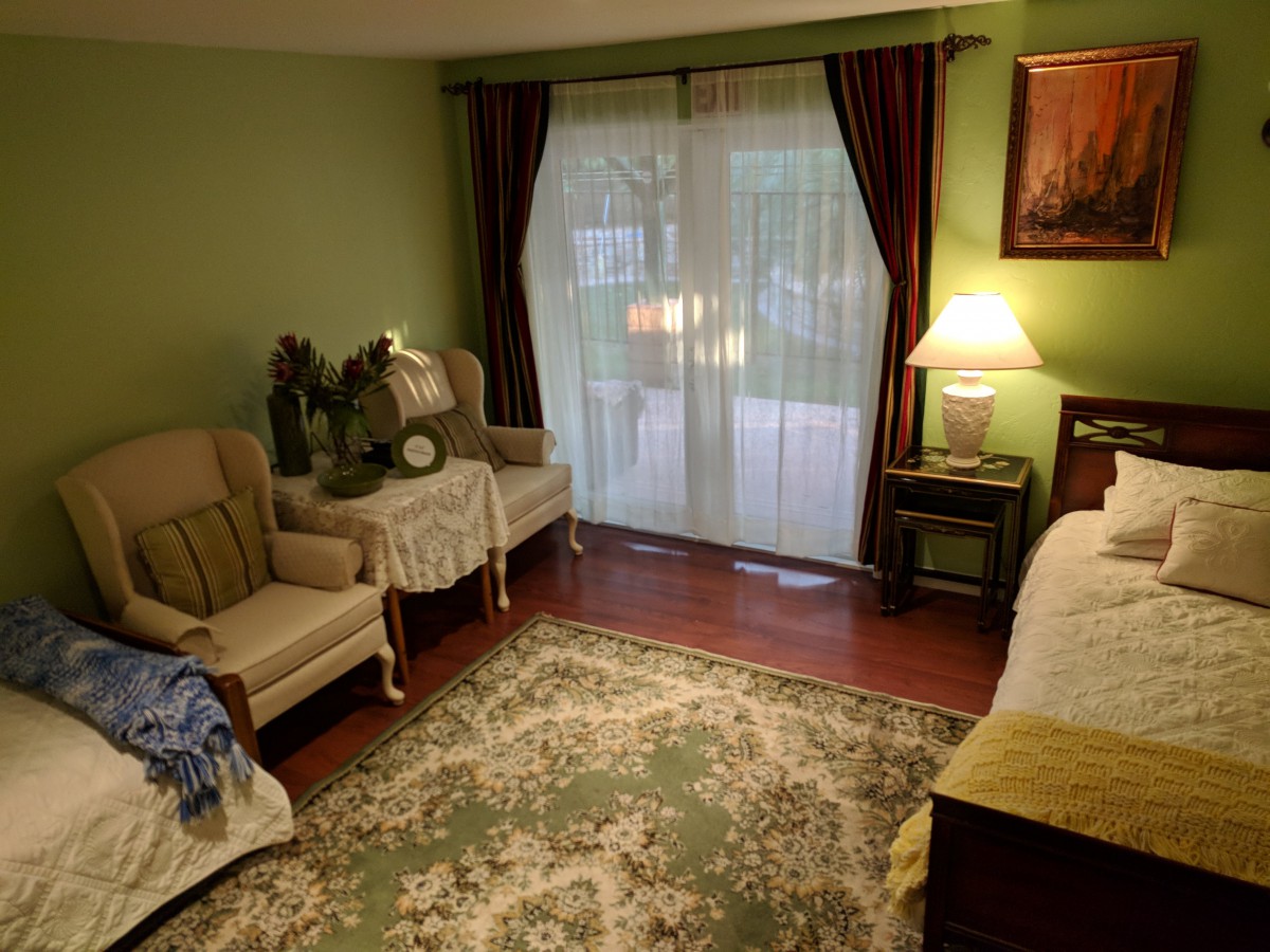 A cozy living room with armchairs, a patterned rug, and warm lighting.