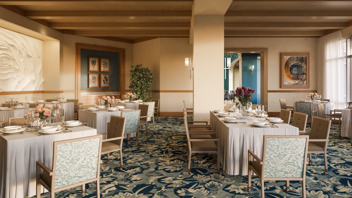 An elegant dining room setup with decorated tables and chairs, featuring floral arrangements and a patterned carpet.