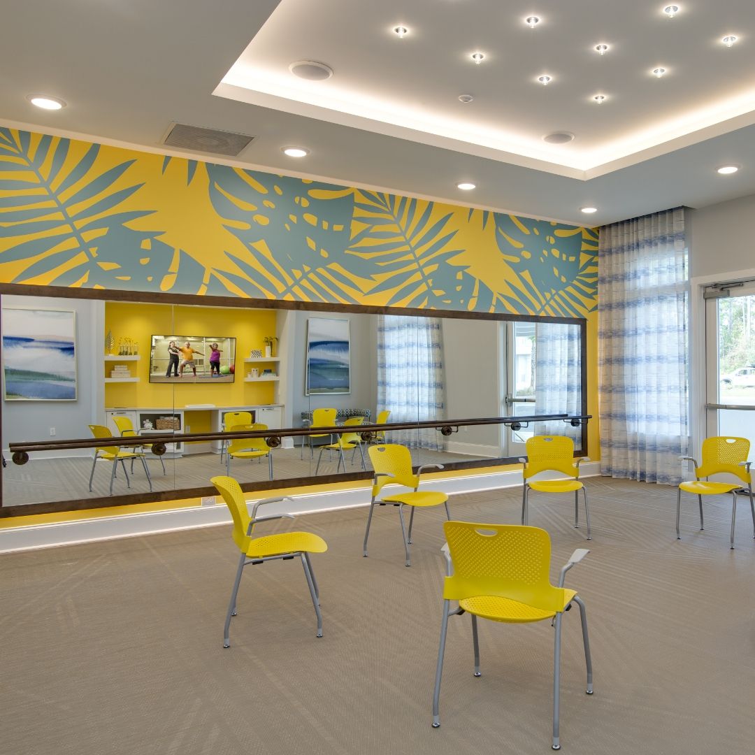 A modern classroom interior with yellow chairs and decorative wall designs.