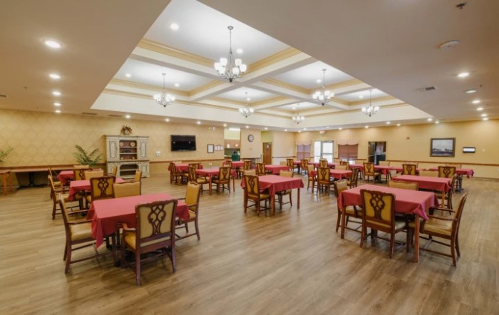 Spacious dining area with elegantly set tables and chandeliers.