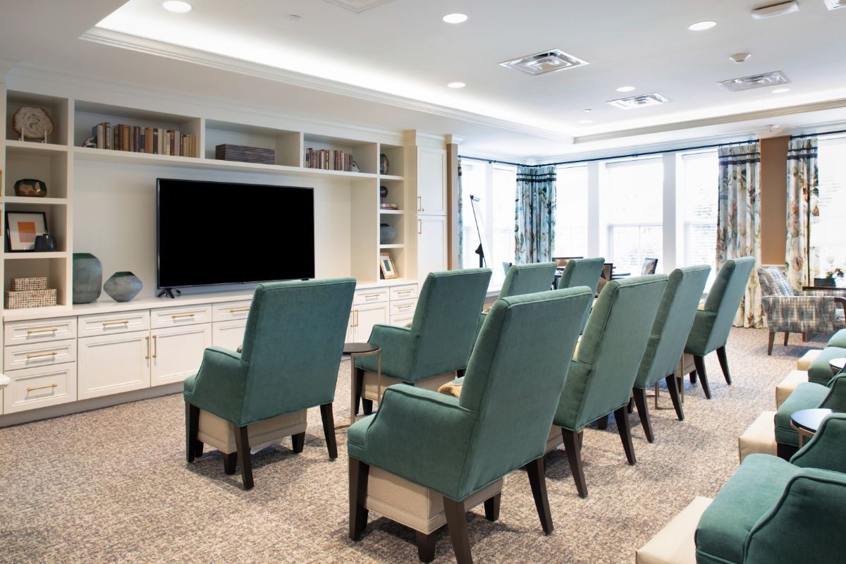 A well-organized seating area facing a large television, resembling a small conference room or home theater.