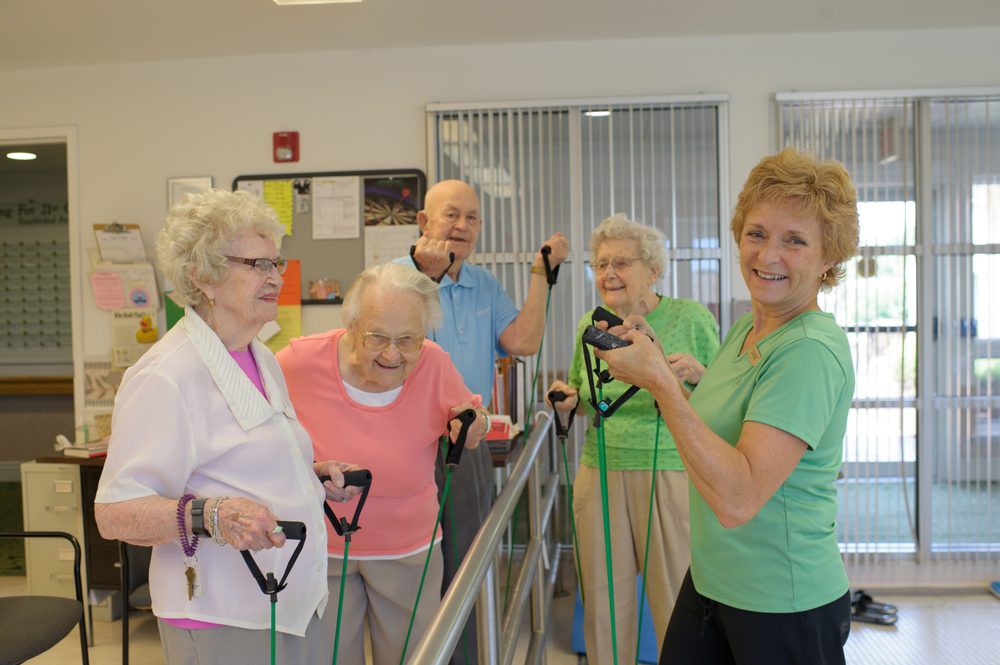 A group of seniors engaging in an indoor exercise session using resistance bands.