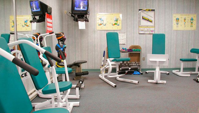 A small indoor gym with various exercise equipment and weights.