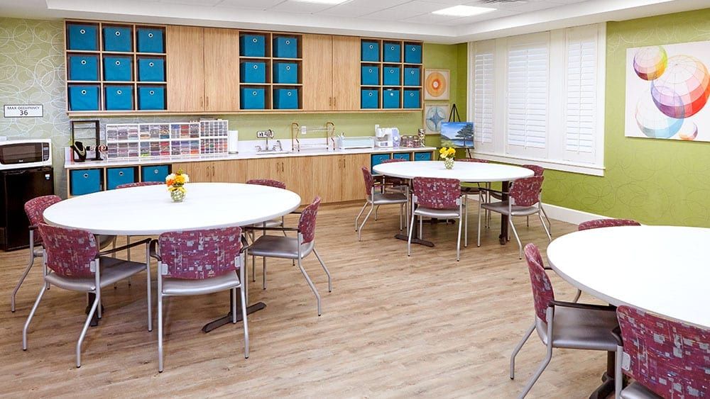 A well-organized classroom with round tables and chairs, designed for group learning.