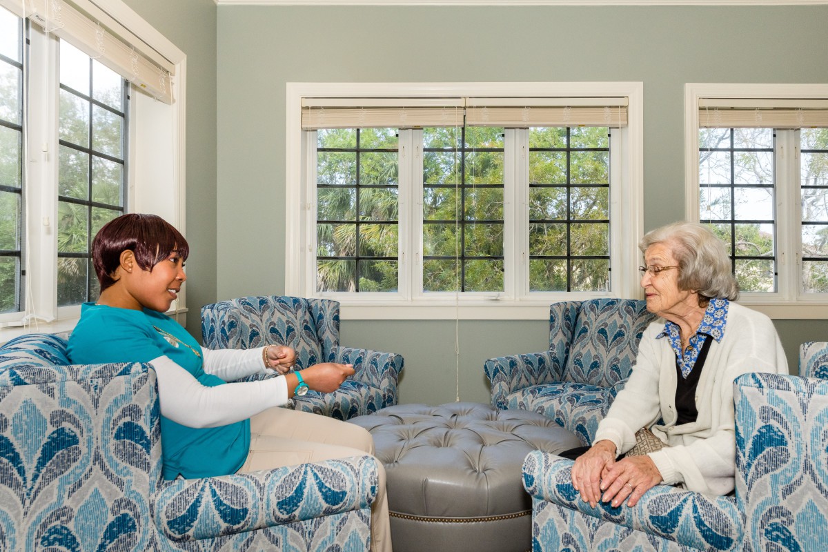 Two people having a conversation in a cozy living room setting.