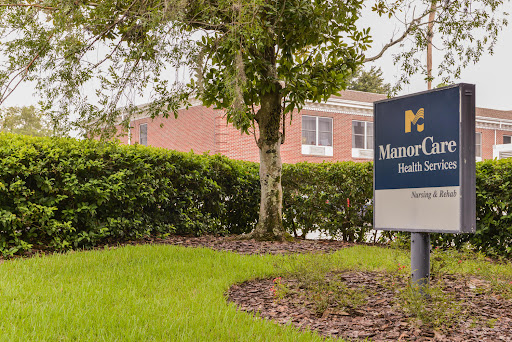 A sign for a facility, surrounded by lush greenery and well-maintained landscaping.