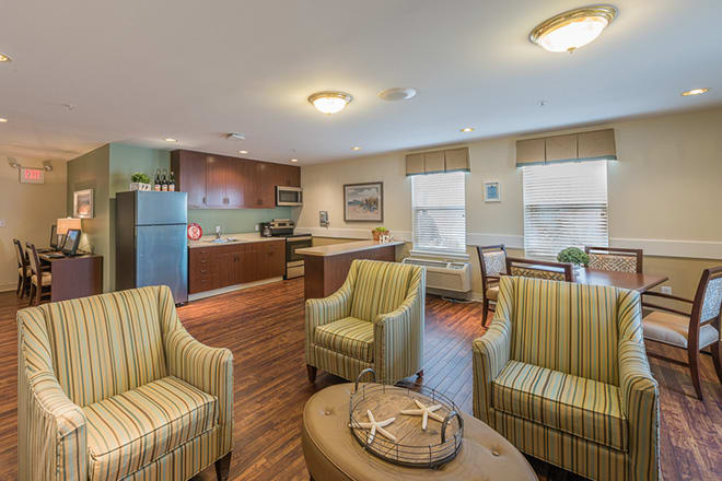 A modern living space with a connected kitchen, featuring comfortable seating and stylish decor.