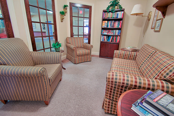 A cozy waiting room with comfortable seating and a bookshelf.