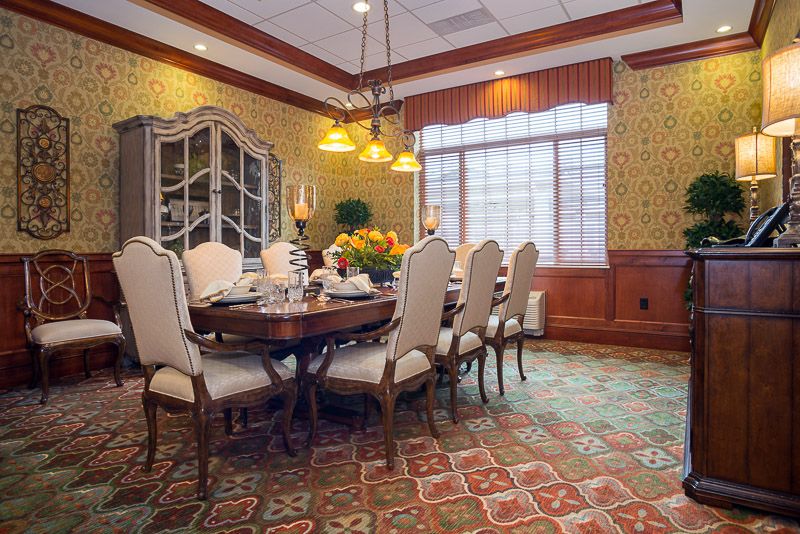 A traditional dining room with an elegant table set, chandelier, and ornate furnishings.