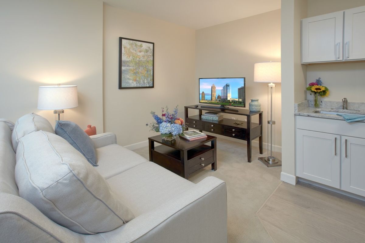 A cozy living room with a sofa, television, and ambient lighting.