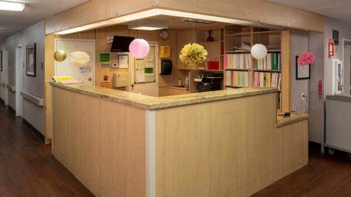 A reception desk area decorated with hanging paper ornaments.