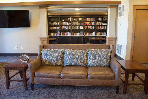 A cozy living room setup featuring a comfortable sofa and a bookshelf filled with books.