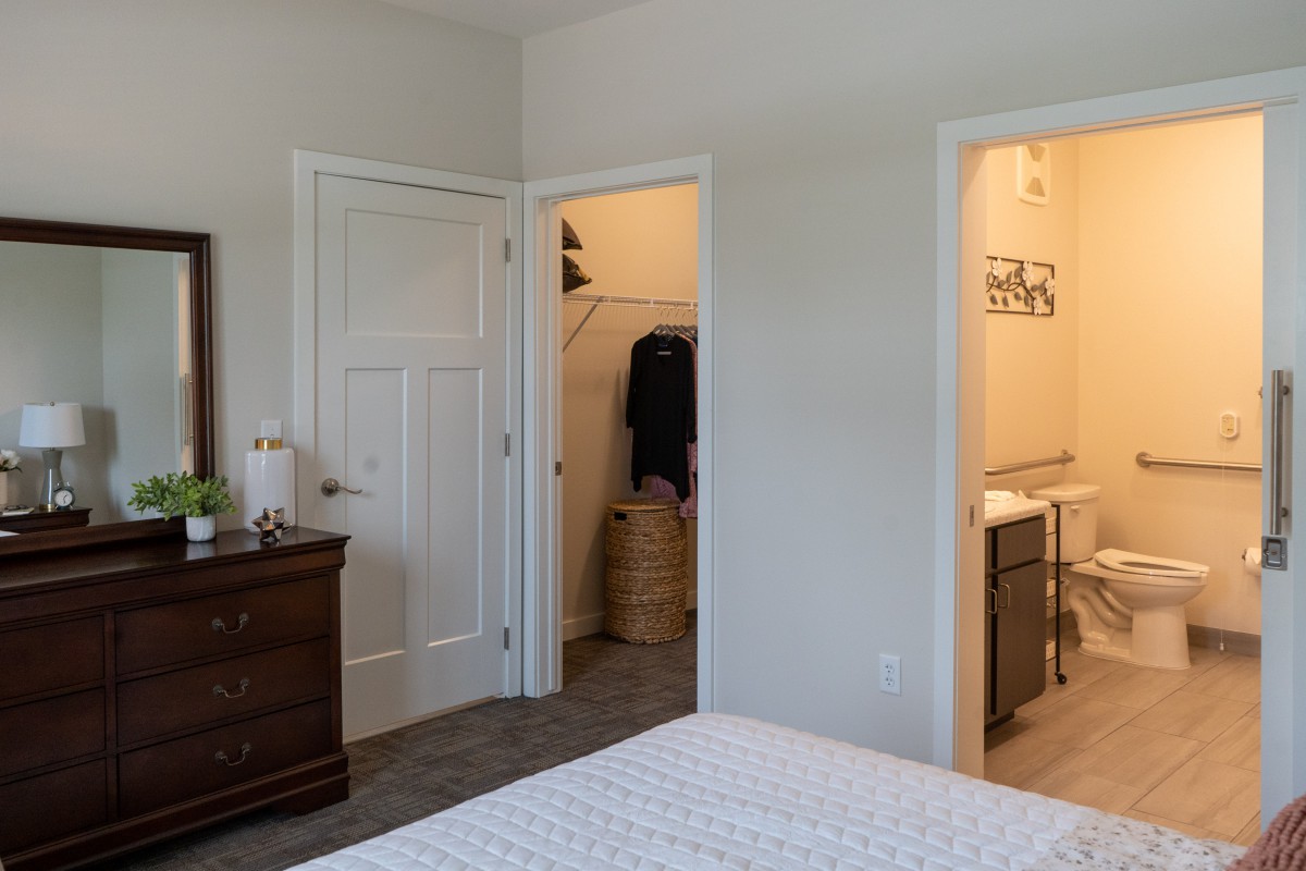 A cozy bedroom with an open closet and adjoining bathroom.