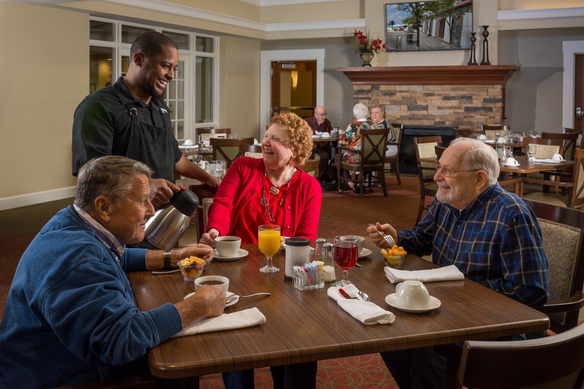 A group of seniors enjoying breakfast and coffee in a cozy restaurant setting.