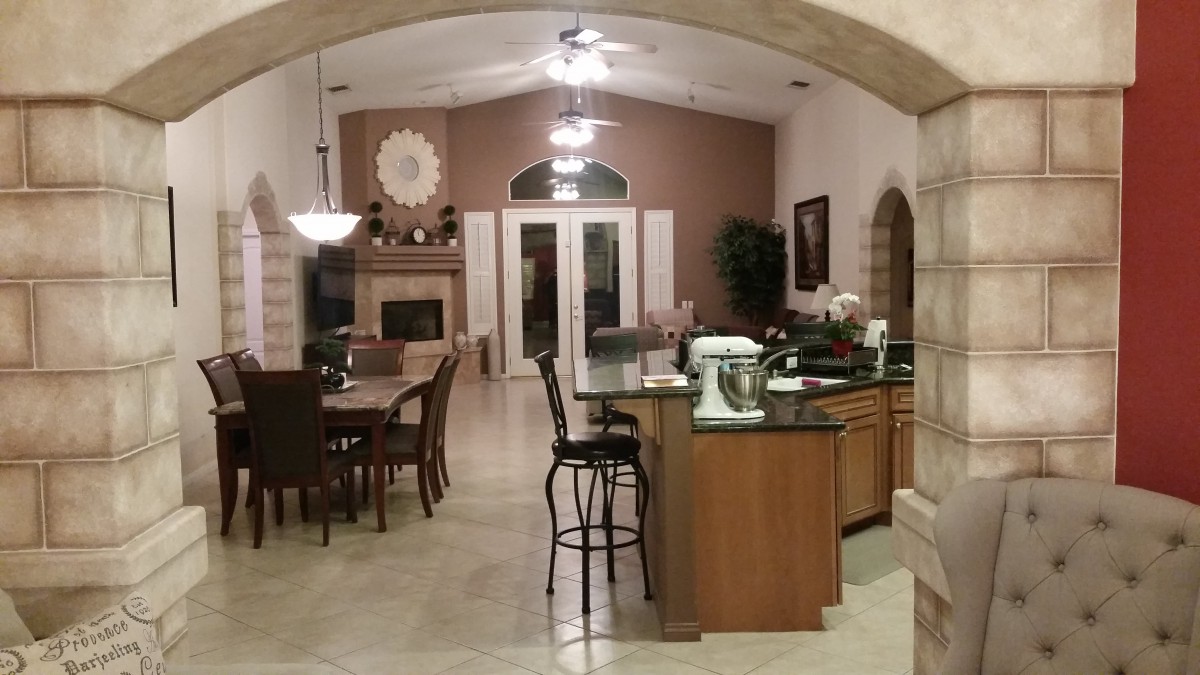 A modern open floor plan kitchen and dining area with elegant furnishings and appliances.