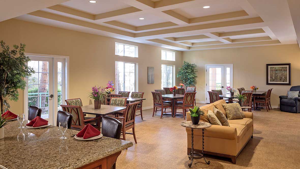 A cozy dining and lounge area with tables, chairs, and warm decor.