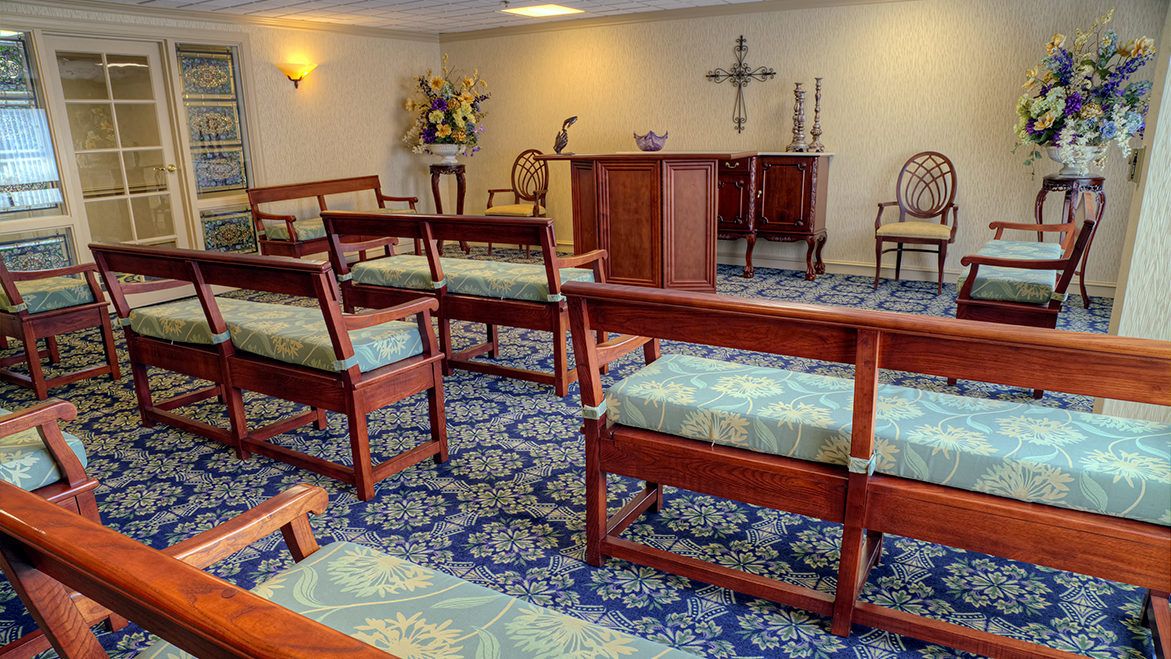 A small chapel with wooden pews and a central altar.