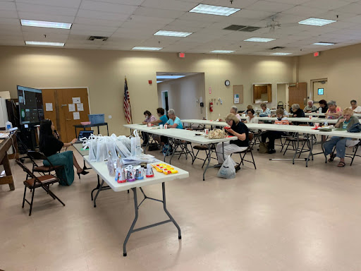 A community gathering in a spacious room with attendees engaged in an activity.