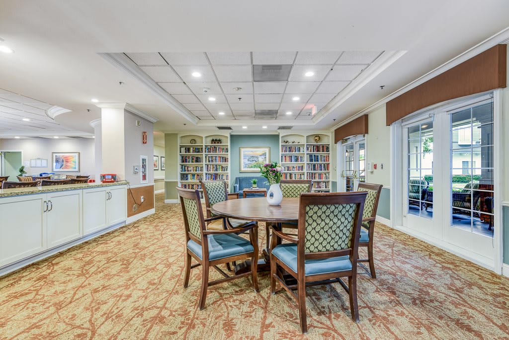 Cozy living area with a table and chairs surrounded by bookshelves.