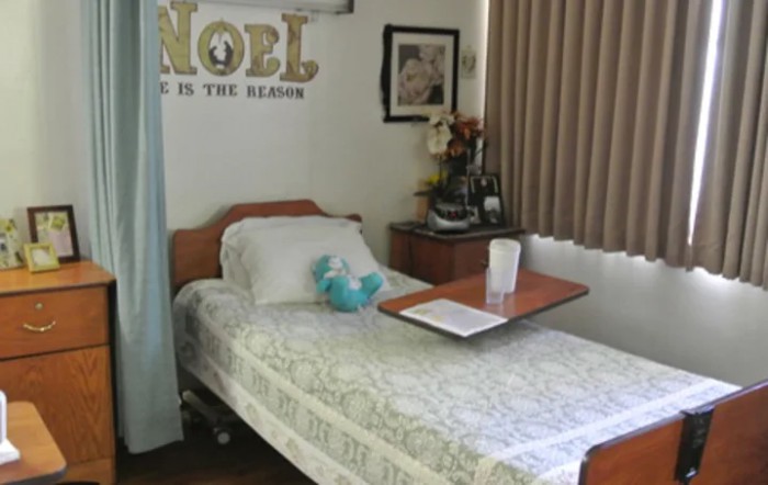 A neatly arranged hospital room with a single bed and medical equipment.