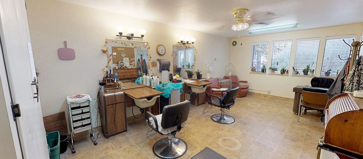 An interior view of a hair salon with styling chairs and mirrors.
