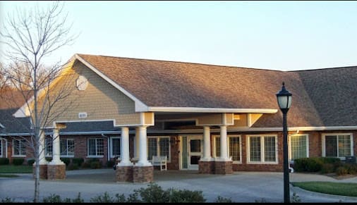 A building with a prominent entrance featuring columns and large windows.