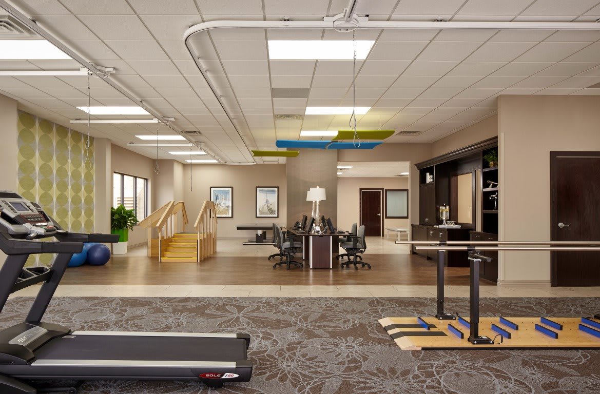 A modern office workspace featuring a treadmill and open design concept.