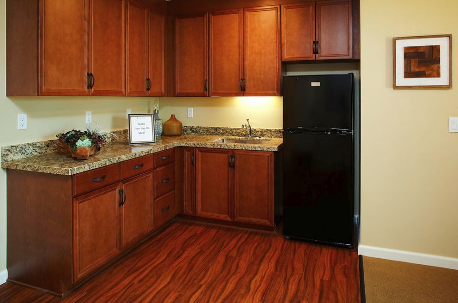 A modern kitchen with wooden cabinets and a granite countertop.