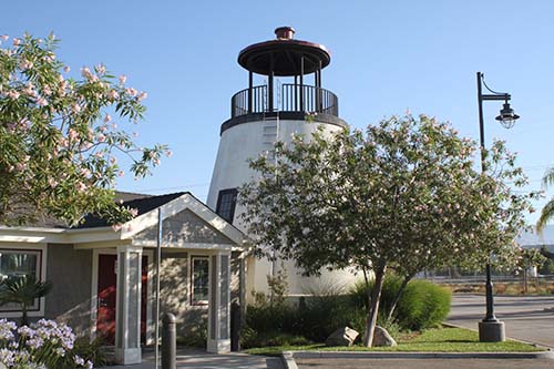 A picturesque lighthouse surrounded by greenery and clear skies.