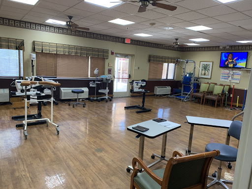 A spacious rehabilitation therapy room equipped with various medical instruments and furniture.