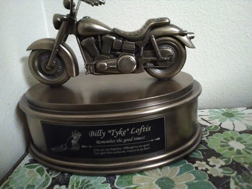 A decorative bronze trophy featuring a motorcycle sculpture.