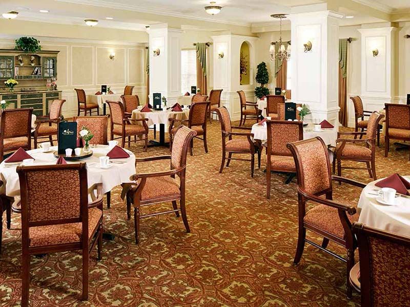 An elegant dining room with neatly arranged tables and chairs.