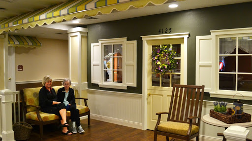 A cozy lobby area with a seated elderly person, featuring decorative elements and inviting seating.