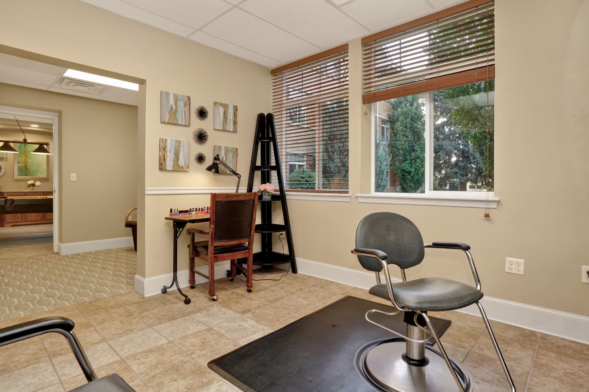 A well-lit workspace with a desk, chair, and large windows.