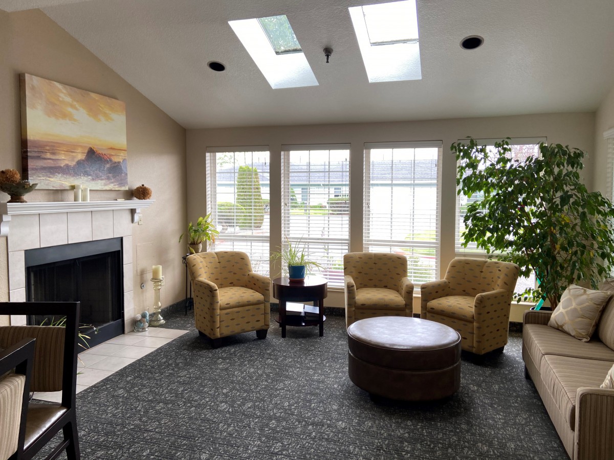 A cozy living room with skylights, comfortable seating, and a fireplace.