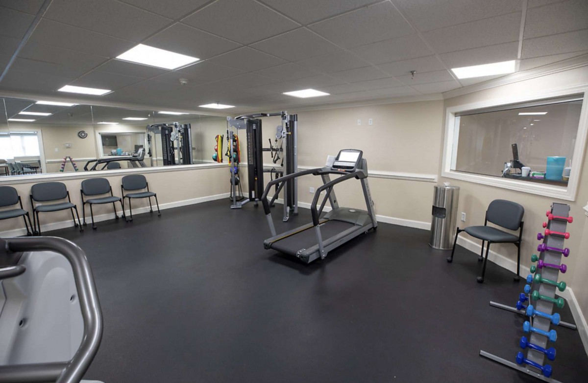 A small gym with a treadmill and various exercise equipment.
