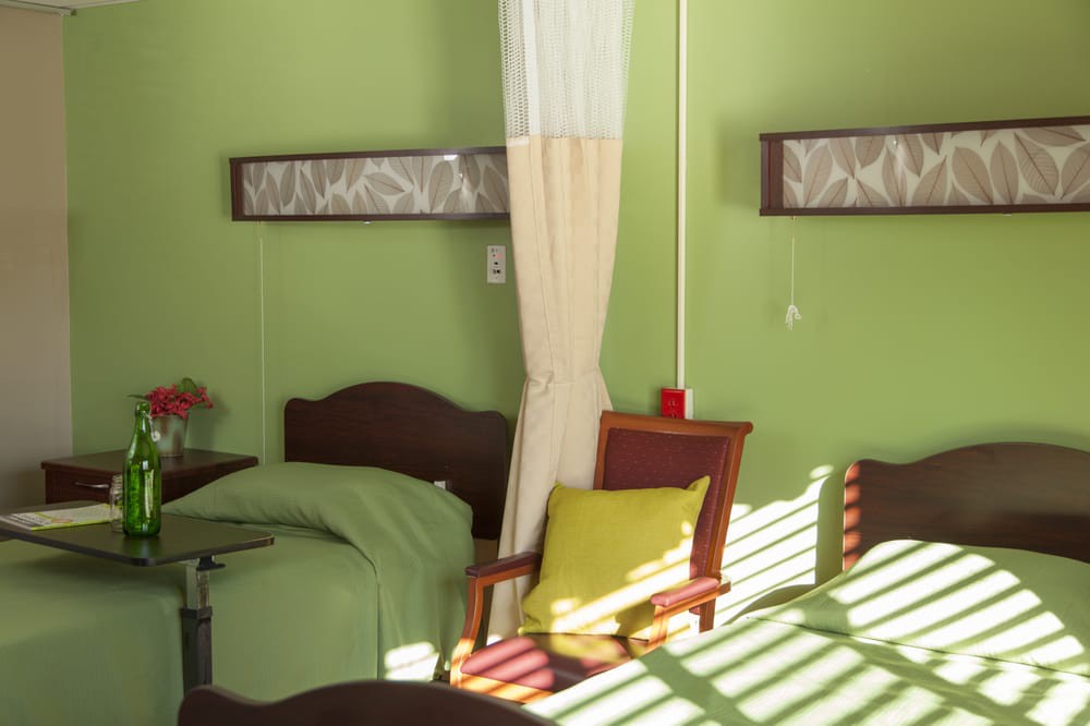 A cozy bedroom with green walls and ample natural light.
