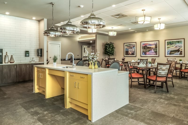 A modern kitchen and dining area featuring a sleek island counter with pendant lighting.