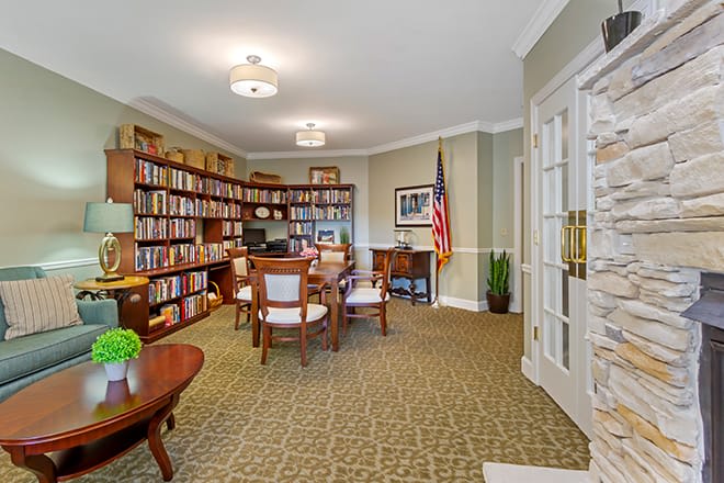A well-organized office space featuring bookshelves, a desk, chairs, and an American flag.