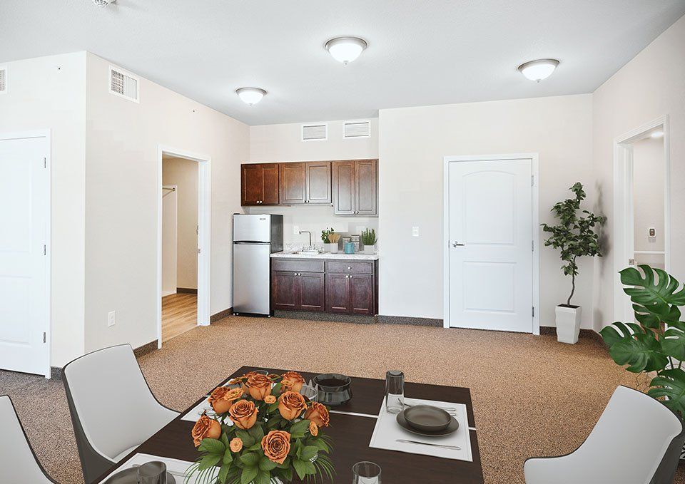 A modern apartment interior featuring a compact kitchen and dining area with stylish furnishings.