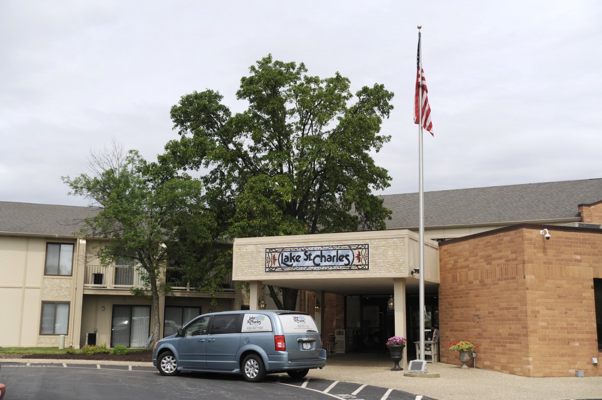 A church building with an American flag and parked van.