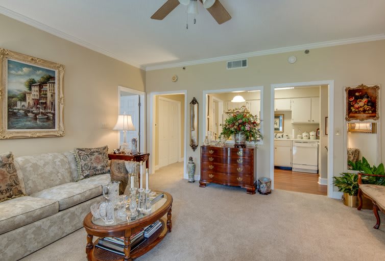 A cozy living room with a sofa, wooden table, and elegant decor.