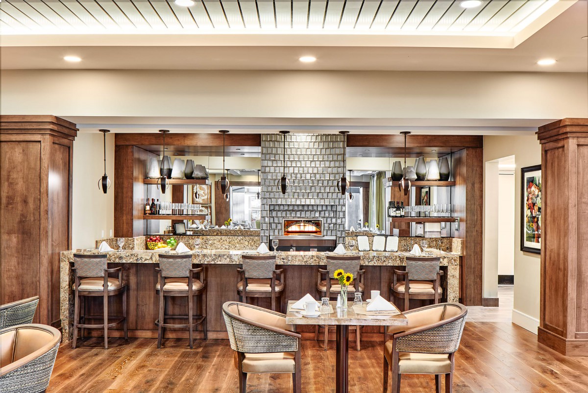A stylish restaurant interior featuring a bar and dining area with modern decor.