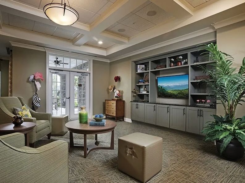 A modern and cozy living room featuring comfortable seating, a large TV, and stylish decor.