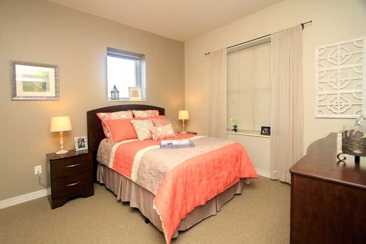 A cozy bedroom with a neatly made bed, bedside tables, and lamps.