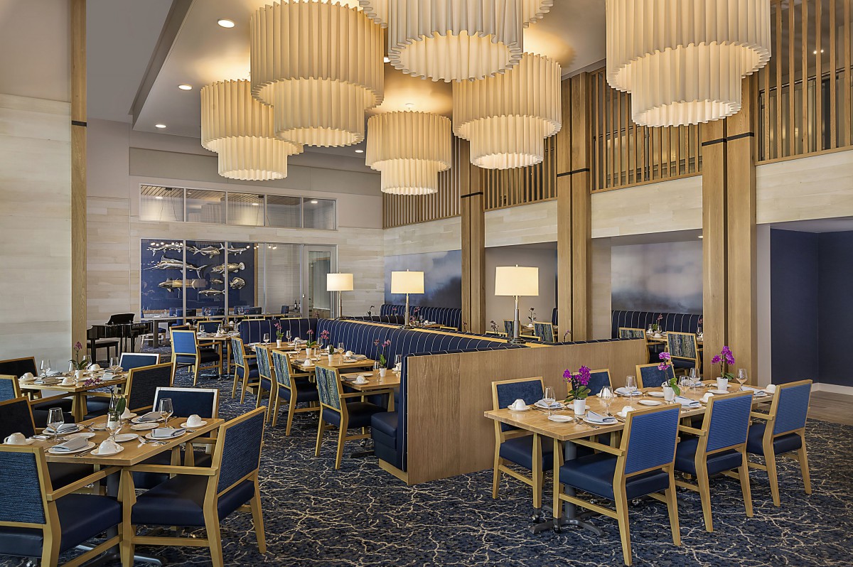 Elegant restaurant interior with stylish chandeliers and neatly arranged dining tables.