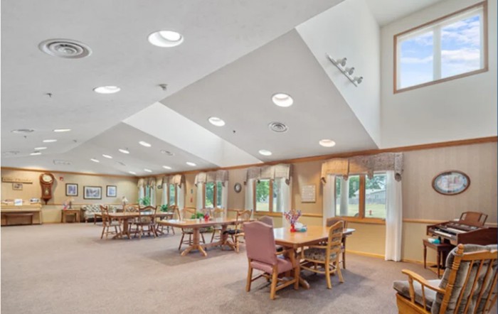 A spacious dining area with ample natural light and multiple tables and chairs arranged neatly.