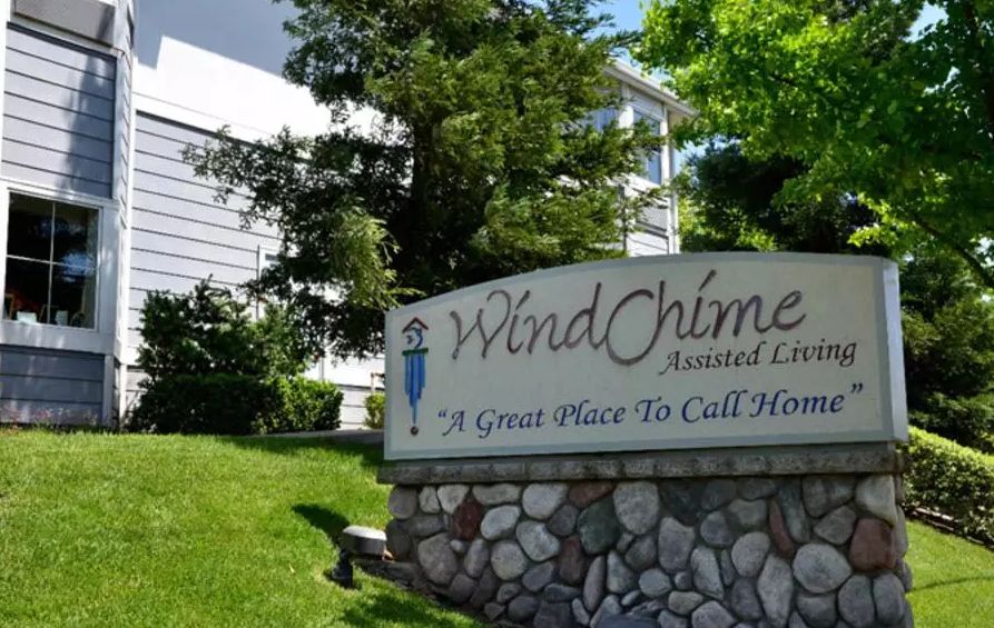 Entrance sign for WindChime Apartment Complex surrounded by greenery.